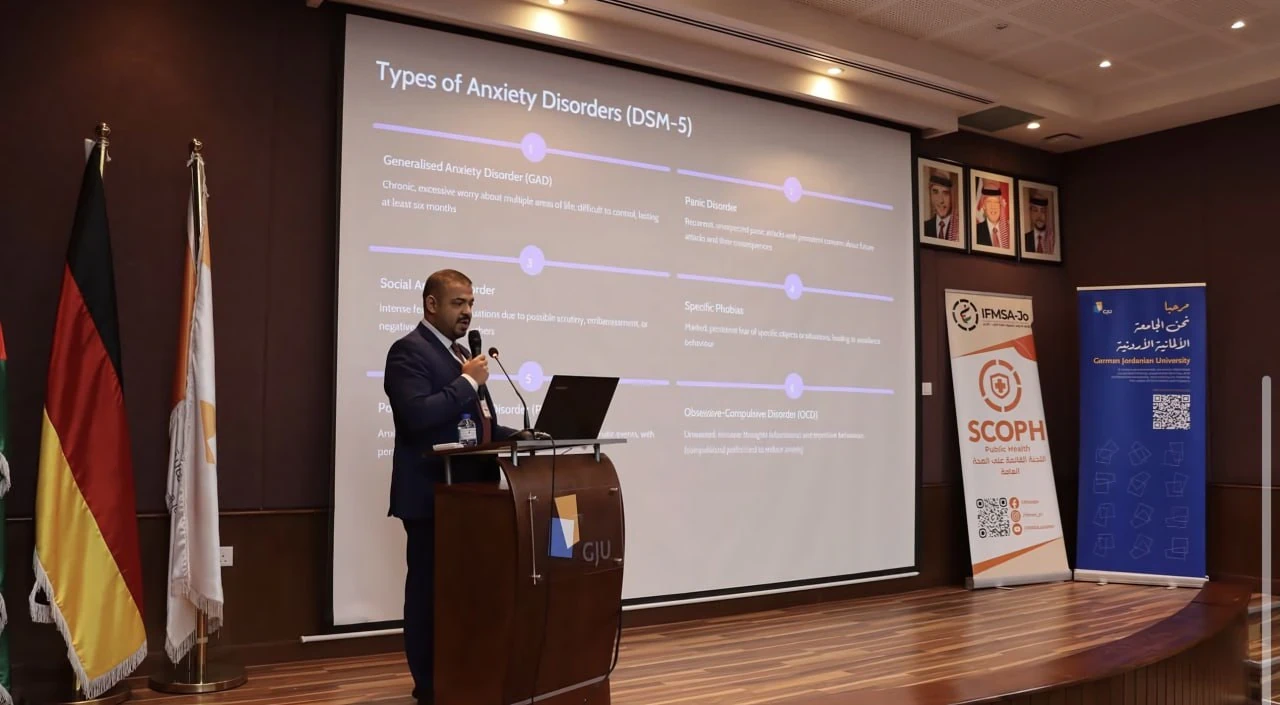 A presenter speaking from the stage in a lecture hall